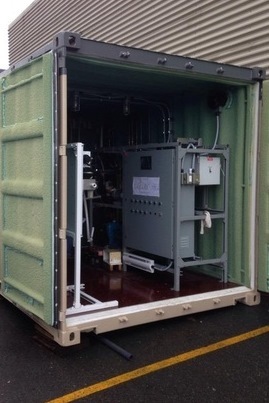 Torak's containerized MBR water treatment plant, doors open on a green shipping container showing the pumps and control cabinet inside.