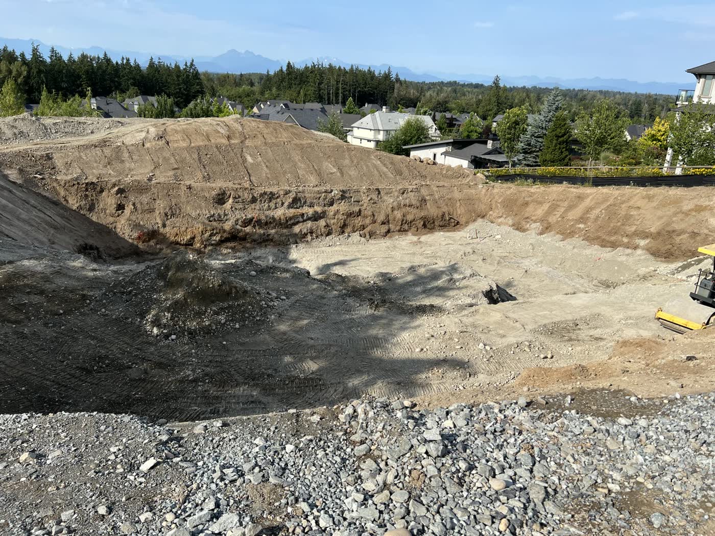 Bulk excavation for a new home on a view lot, banks cut back and the floor of the dig levelled.